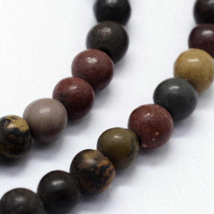 Natural Dendritic Jasper Beads, Round, Dark Multi Color. Semi-Precious Gemstone Beads for Jewelry Making.   Size: 6mm Diameter, Hole: 0.8mm; approx. 60-63pcs/strand, 14.75" inches long.  Material: The Beads are Natural Dendritic Jasper Stone. Polished, Shinny Finish.  Dendritic Jasper Properties: This Stone is Believed to Bring Clarity of Mind and Sharp Thinking. Dendritic Jasper is very good for writers and inventors. It is a stone that encourages creativity and idealistic thinking.